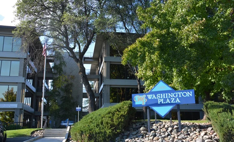 Washington Plaza signboard with buildings in the background, showcasing the location's name prominently